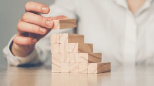 hand builds a ladder from wooden blocks