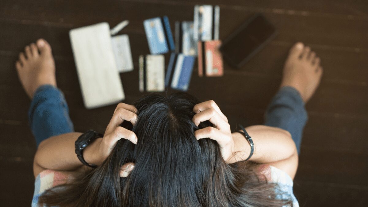 a top view of a stressed young Asian woman trying to find money to pay her credit card debt