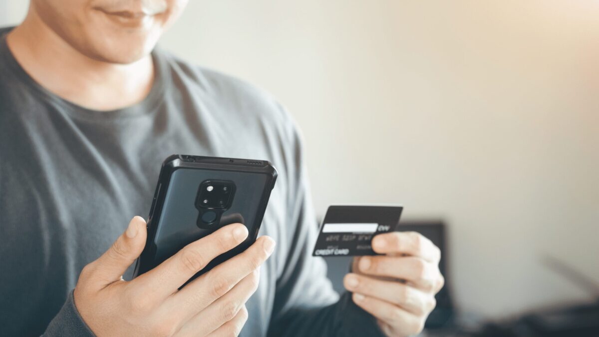 a businessman uses their credit cards through a mobile internet banking app to shop online and make a digital payment