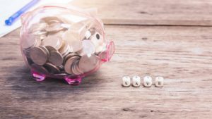 a piggy bank sits next to blocks with the word “save” spelled out to show ways to build credit without spending money