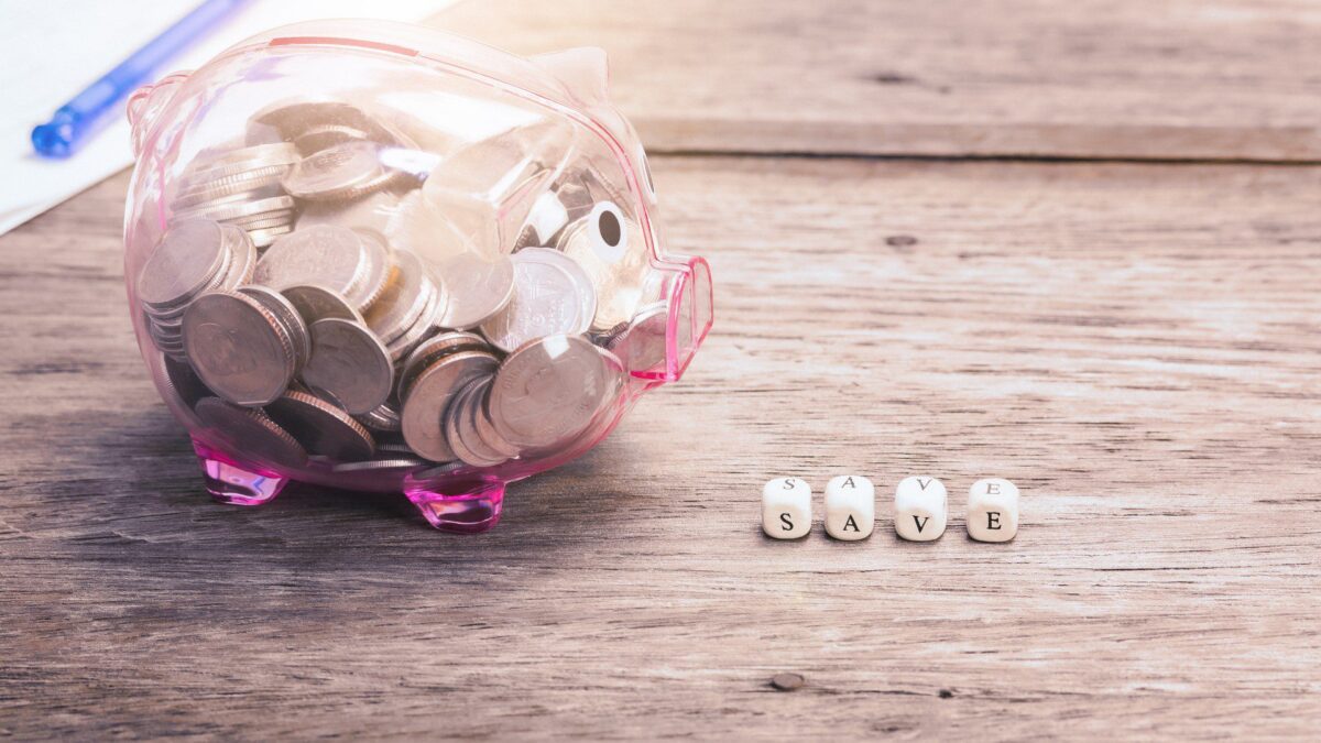 a piggy bank sits next to blocks with the word “save” spelled out to show ways to build credit without spending money
