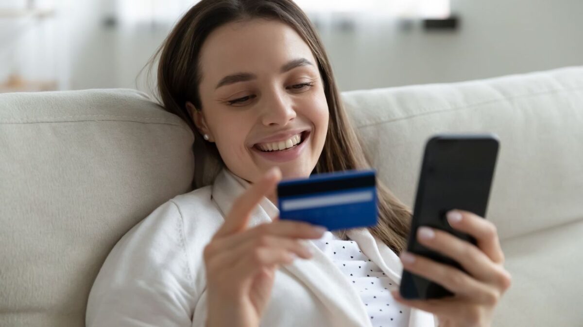 Woman smiling while making a loan payment with her credit card using her phone | Wise Loan