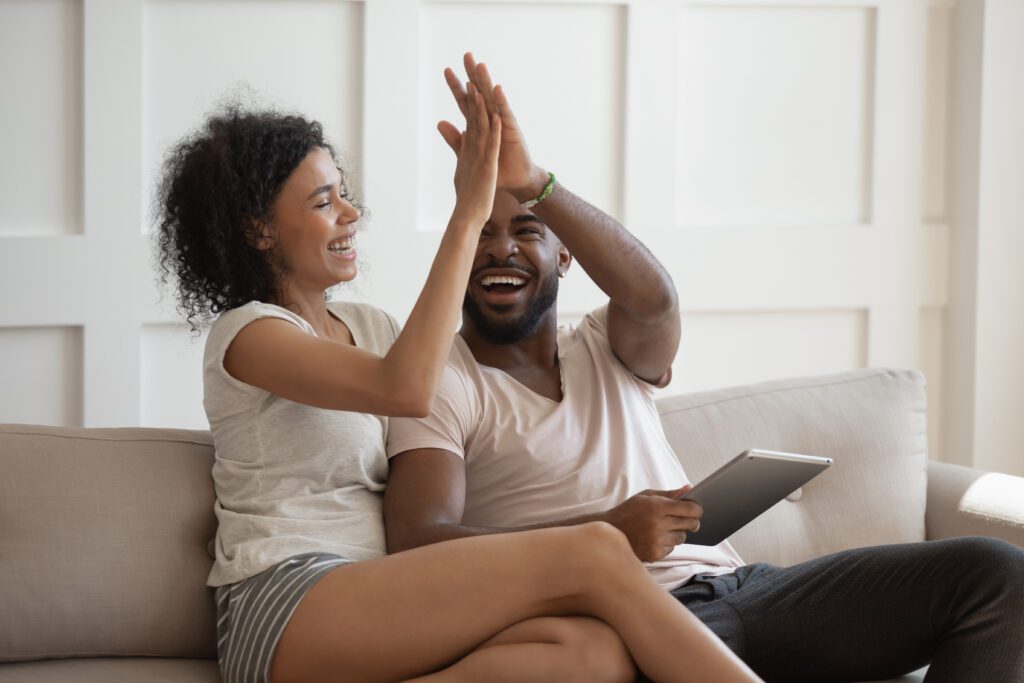Happy couple high-fives as they apply for loan with Wise Loan | Auto repair financing options