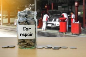 Jar full of quarters sitting on desk in front of mechanic shop | Auto repair financing options