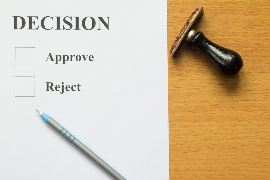 Paper with check boxes for approval or rejection laying on wooden desk | Auto repair financing options