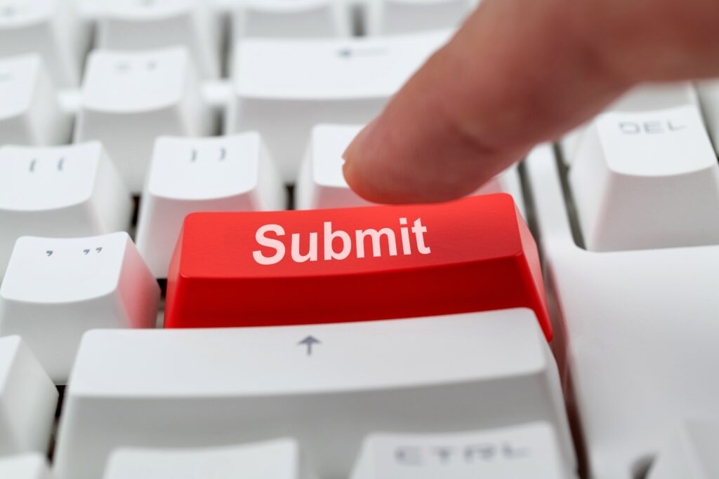 Close up of finger pushing red submit button on white keyboard | Auto repair financing options