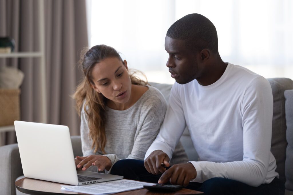 Couple sitting on couch discusses funeral loan application | Funeral financing options