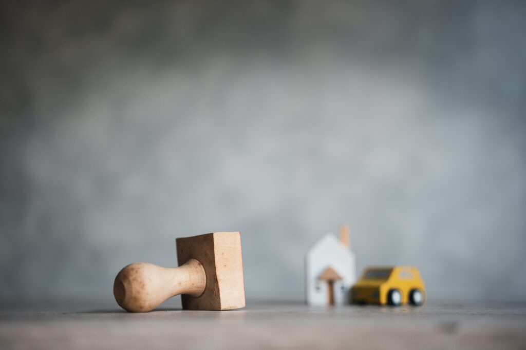 Approval stamp rests on foreground as model home and model car rest in background | How to get a moving loan