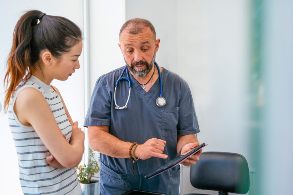 Woman discusses veterinary financing options with tech in gray scrubs | How to get a veterinary loan