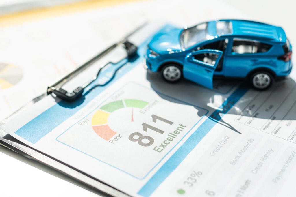 Blue model car sits on top of credit report on clipboard | How to get an auto repair loan