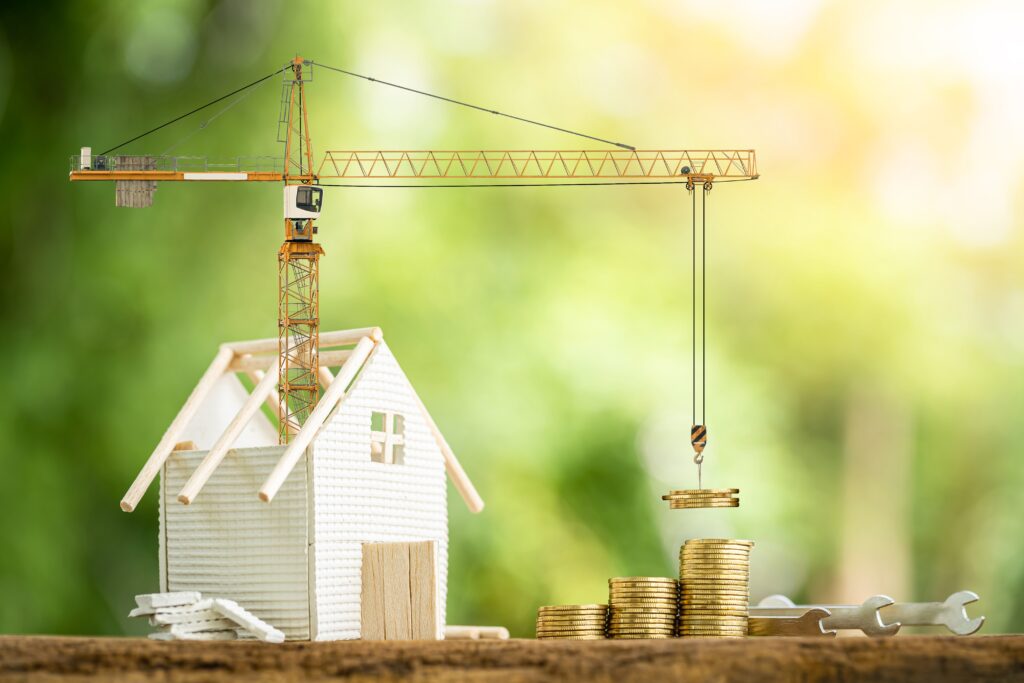 Crane emerges from model home to drop coins on coin stack | How to get a home repair loan