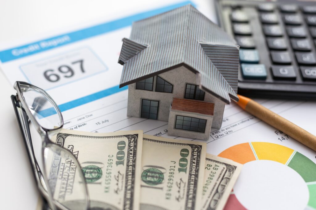 Eyeglasses, model home, and cash rest on top of printed credit report | How to get a moving loan