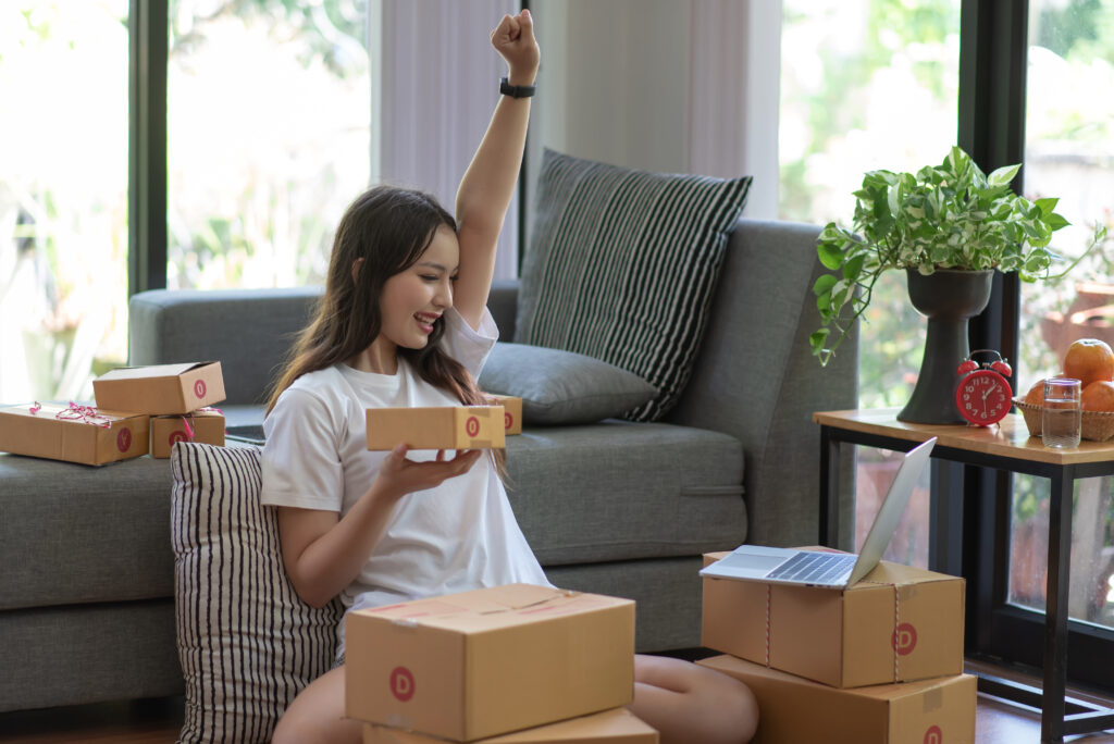 Woman cheers when seeing new order as she packs cardboard boxes of sold items | Ways to get emergency money