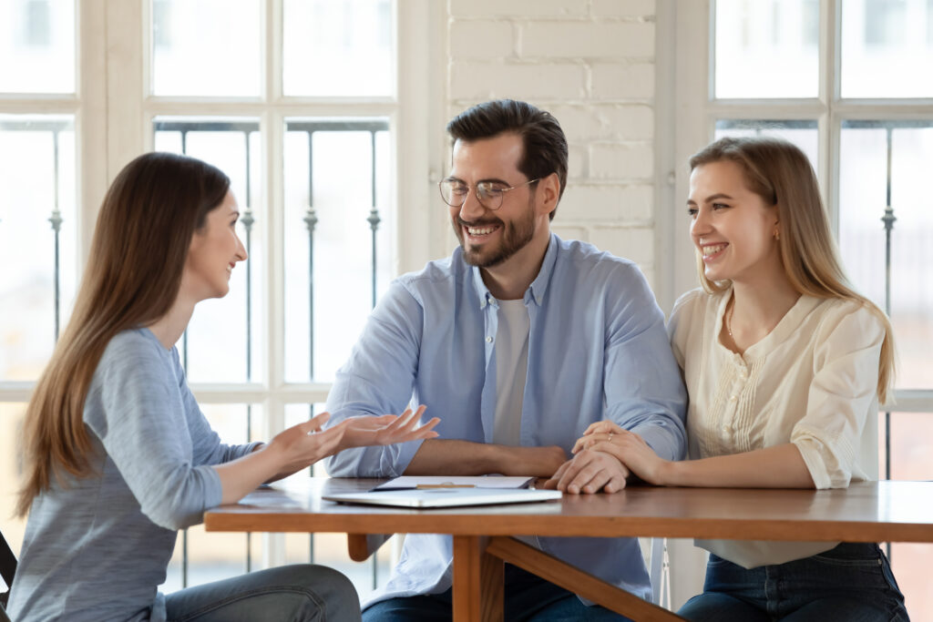 Young couple smiles as talk to emergency loan lender in office | 9 types of emergency loans