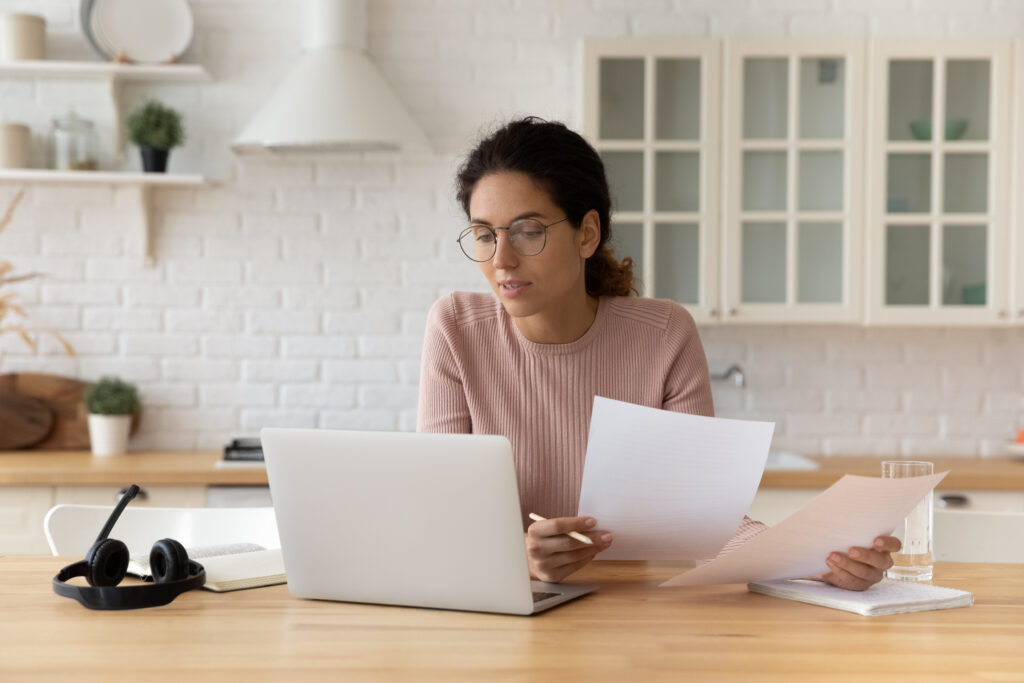 Woman sitting at kitchen counter compares loan options on laptop | Best emergency loans
