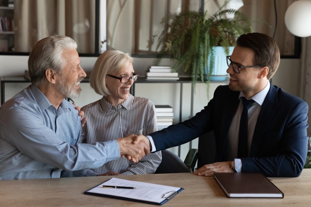 Couple shakes hands with loan agent as they apply for emergency funding | Best emergency loans for bad credit