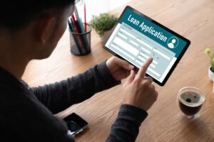 A man completing a loan application on a tablet | Best personal loans