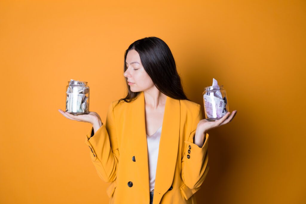 A woman holding two glass jars filled with money | Loans like Upstart