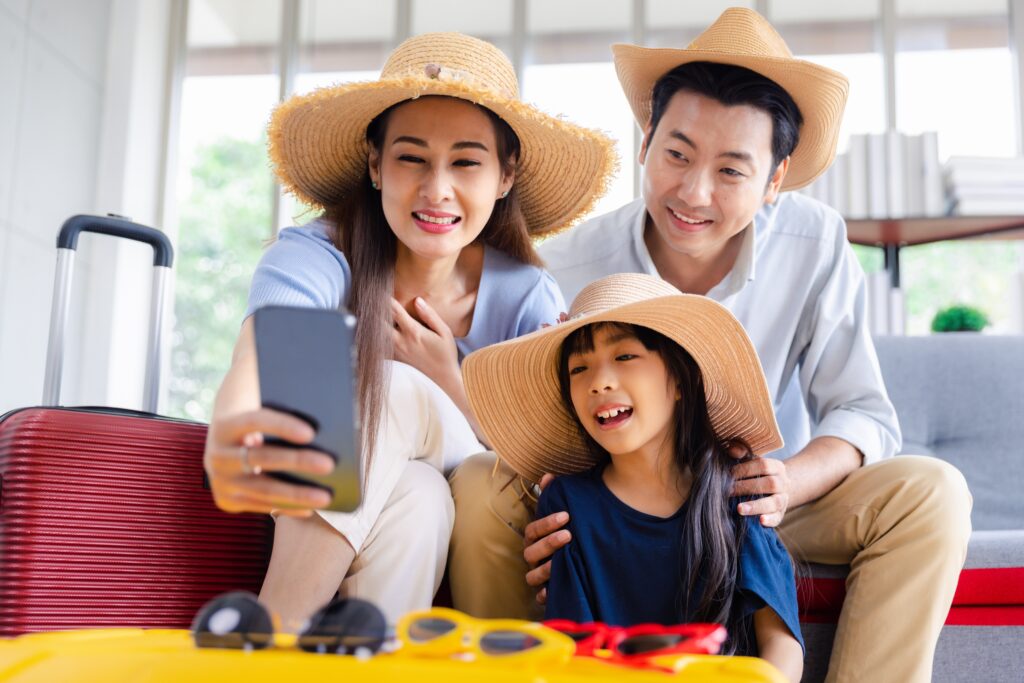 Parents smile while looking at vacation booking confirmation with small daughter | Best Vacation Loans